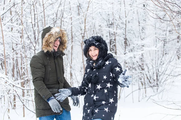 Jovem casal brincando com neve no parque de inverno — Fotografia de Stock