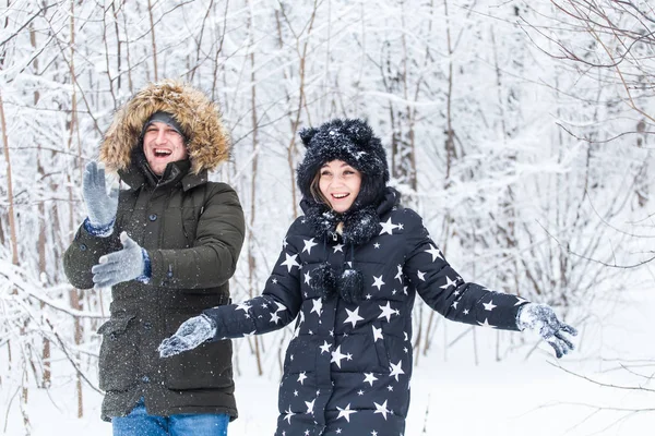 คู่รักหนุ่มสาวเล่นกับหิมะในสวนฤดูหนาว — ภาพถ่ายสต็อก