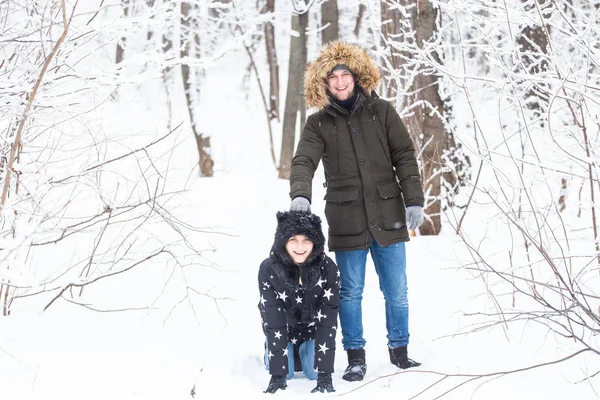 Diversión, temporada y concepto de ocio - pareja de amor juega madera de invierno en la nieve — Foto de Stock