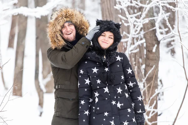 Fun, concept de saison et de loisirs - couple amoureux joue du bois d'hiver sur la neige — Photo