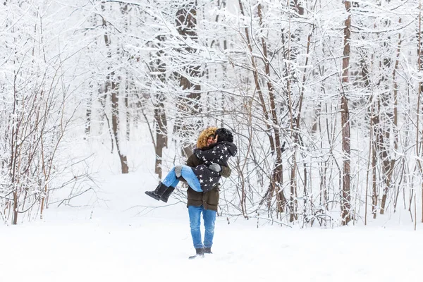 Jovem casal apaixonado se divertir na floresta nevada. Férias activas de Inverno. — Fotografia de Stock