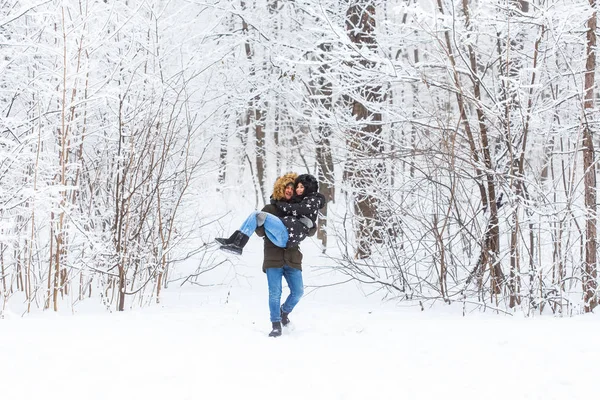 Feliz casal amoroso se divertindo ao ar livre no parque de neve. Férias inverno — Fotografia de Stock