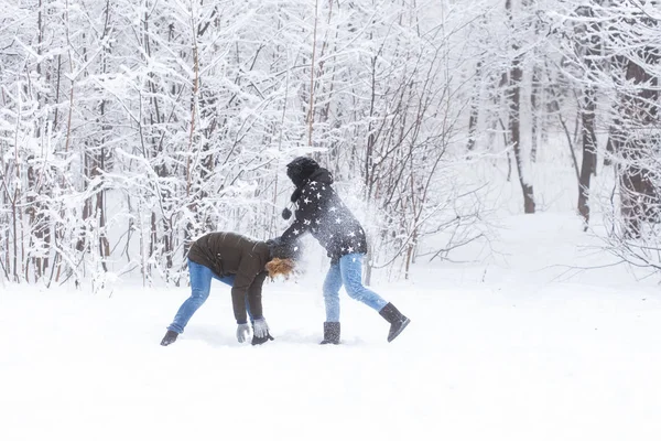 Estilo de vida, temporada e conceito de lazer - Engraçado casal jogando bola de neve no parque de inverno — Fotografia de Stock