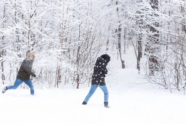 Mode de vie, saison et concept de loisirs - Couple drôle jouant boule de neige dans le parc d'hiver — Photo