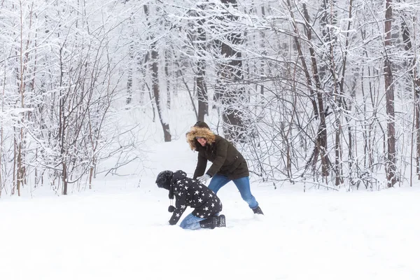 Estilo de vida, temporada e conceito de lazer - Engraçado casal jogando bola de neve no parque de inverno — Fotografia de Stock