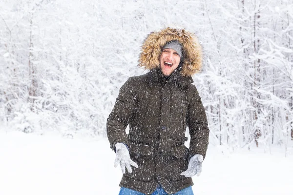 Šťastný legrační mužský portrét hledá sněhové vločky padající dolů — Stock fotografie