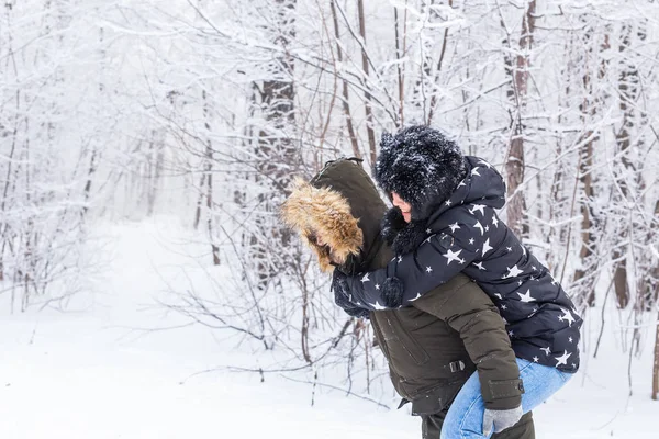 Portrait de jeune couple heureux dans le parc d'hiver avec leur ami derrière — Photo