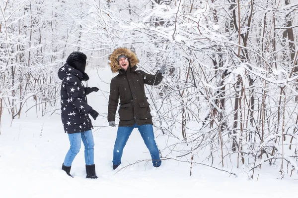 Jeune couple amoureux amusez-vous dans la forêt enneigée. Vacances d'hiver actives. — Photo