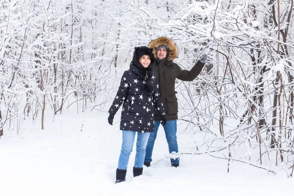 Jeune couple amoureux amusez-vous dans la forêt enneigée. Vacances d'hiver actives. — Photo