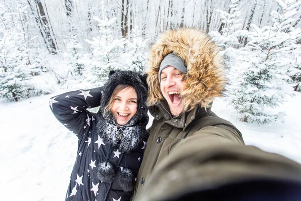 Man taking selfie photo young romantic couple smile snow forest outdoor winter — ストック写真