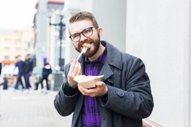Man holding one-off plate with traditional delicious jewish food falafel made of chickpeas at the street food festival
