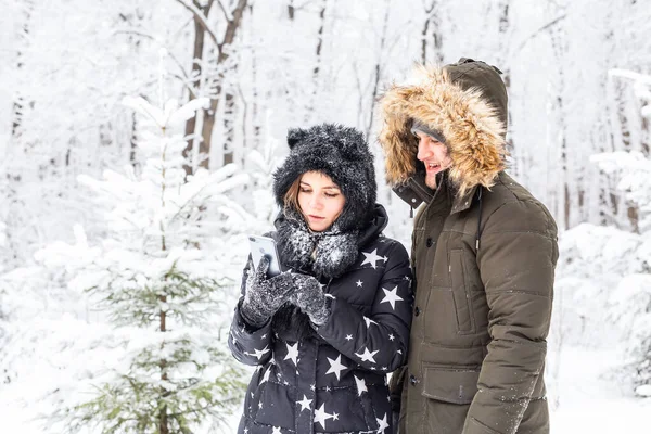 Technologie i koncepcja relacji - Szczęśliwa uśmiechnięta para robi selfie w zimowym lesie na zewnątrz — Zdjęcie stockowe