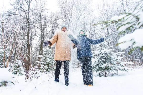 Parenting, fun et concept de saison - Bonne mère et son fils s'amusent et jouent avec la neige dans la forêt d'hiver — Photo