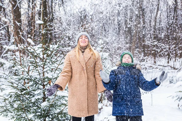 어버이, 재미, 계절 개념 - 행복 한 어머니 와아들이 겨울 숲에서 재미를 보며 눈 놀이를 하는 모습 — 스톡 사진