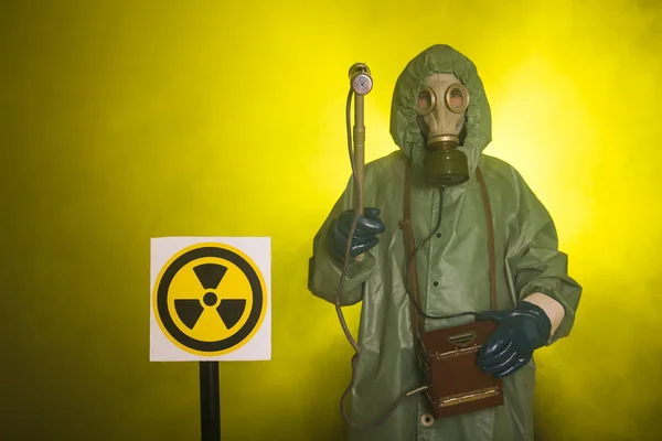 Radiation, pollution and danger concept - Man in protective clothing and a gas mask on a dark background