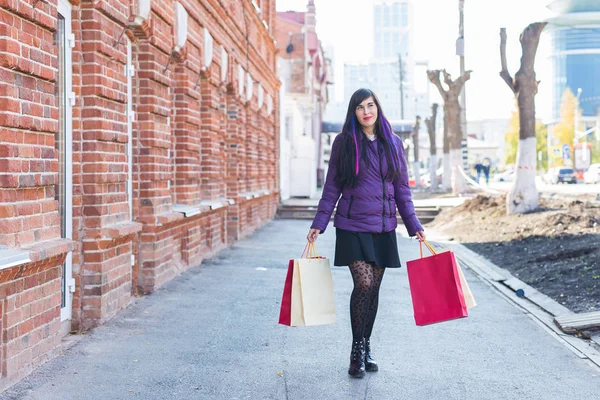 Αγορές, τους καταναλωτές και τις πωλήσεις έννοια - Όμορφη γυναίκα κρατώντας πολλές τσάντες ψώνια σε ένα δρόμο της πόλης — Φωτογραφία Αρχείου