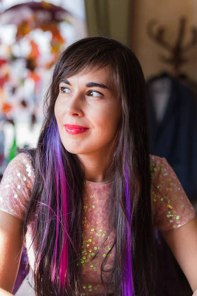 Jovem elegante mulher da moda com fios multi-coloridos no cabelo senta-se no café — Fotografia de Stock