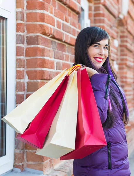 Conceito de compras, consumo e vendas - Mulher bonita segurando muitos sacos de compras em uma rua da cidade — Fotografia de Stock