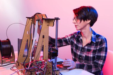 3D yazıcıdaki ürünü yapan kadın öğrenci