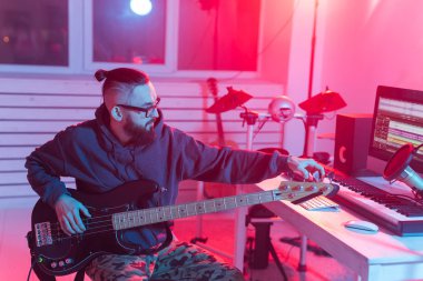 Müzik ve stüdyo konsepti yaratmak - sakallı adam gitarist ev stüdyosunda elektro gitar kaydı yapıyor