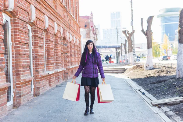 Shopping, konsument och försäljning koncept - Vacker kvinna som håller många shoppingväskor på en stadsgata — Stockfoto