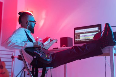 Müzik ve stüdyo konsepti yaratmak - sakallı adam gitarist ev stüdyosunda elektro gitar kaydı yapıyor