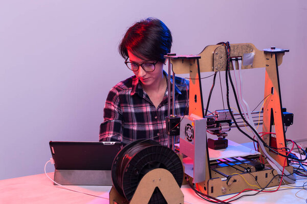 Female architect using 3D printer in office