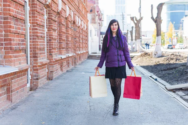 Shopping, konsument och försäljning koncept - Vacker kvinna som håller många shoppingväskor på en stadsgata — Stockfoto