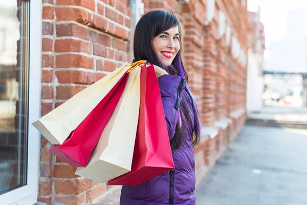 Conceito de compras, consumo e vendas - Retrato de mulher bonita segurando muitos sacos de compras em uma rua da cidade — Fotografia de Stock