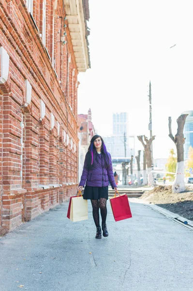 Shopping, konsument och försäljning koncept - Vacker kvinna som håller många shoppingväskor på en stadsgata — Stockfoto