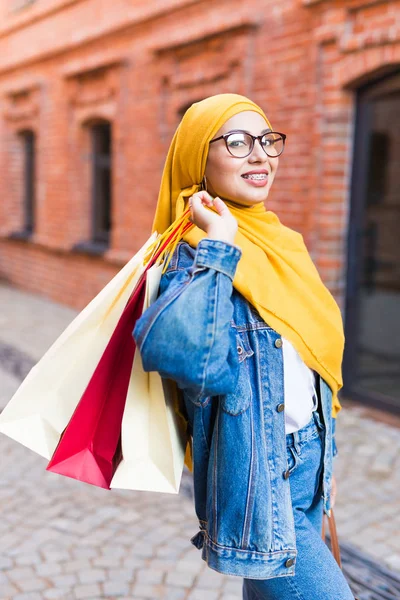 Sale and buying concept - Happy arab muslim girl with shopping bags after mall — Stock Photo, Image