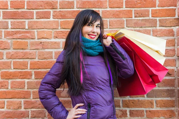 Einkaufs-, Konsum- und Verkaufskonzept - Schöne Frau mit vielen Einkaufstüten über Backsteinmauer-Hintergrund auf einer Stadtstraße — Stockfoto