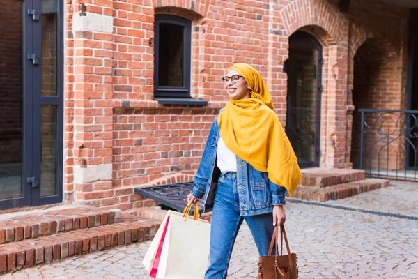 Kauf- und Verkaufskonzept - Glückliches arabisches muslimisches Mädchen mit Einkaufstüten nach Einkaufszentrum — Stockfoto