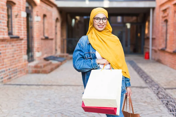 Kauf- und Verkaufskonzept - Glückliches arabisches muslimisches Mädchen mit Einkaufstüten nach Einkaufszentrum — Stockfoto