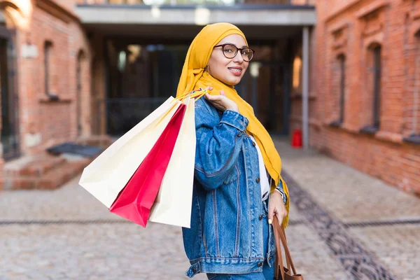 Sale and buying concept - Happy arab muslim girl with shopping bags after mall — Stock Photo, Image