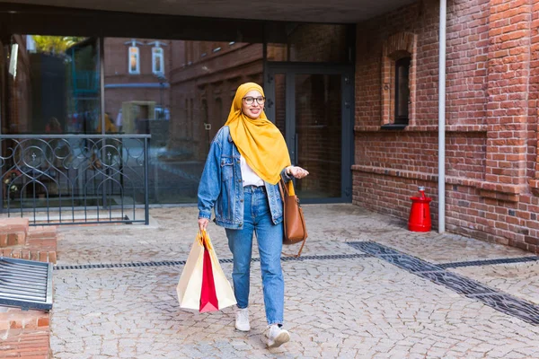 쇼핑을 마치고 쇼핑백을 들고 있는 행복 한 아랍 회교도 소녀 — 스톡 사진