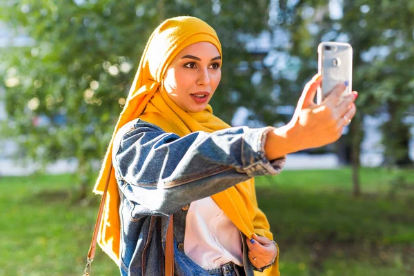 Muslimisches Mädchen im Hidschab macht ein Selfie am Telefon, das auf der Straße der Stadt steht — Stockfoto