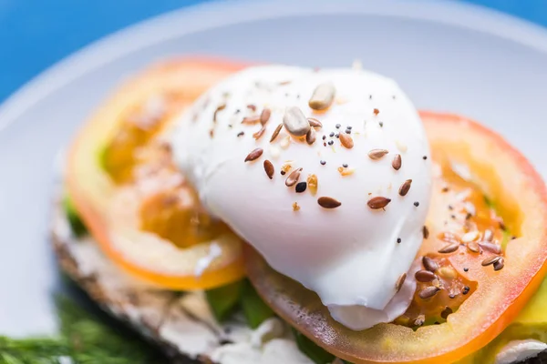 Sandwich au saumon fumé, oeuf et avocat sur fond bleu. Concept pour une alimentation saine . — Photo