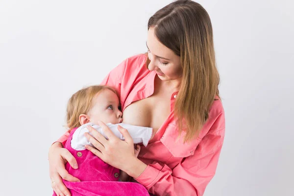 Maternidad, lactancia materna y concepto de bebé - La madre está amamantando a su hija — Foto de Stock