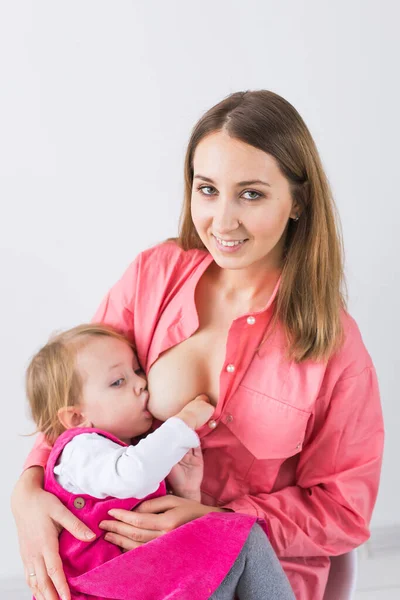 Maternidade, amamentação e conceito infantil - A mãe está amamentando sua filha bebê — Fotografia de Stock