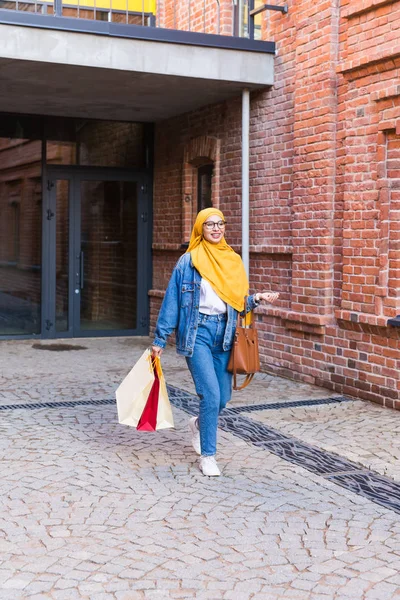 Försäljning och inköp koncept - Happy arab muslim flicka med shoppingväskor efter köpcentret — Stockfoto