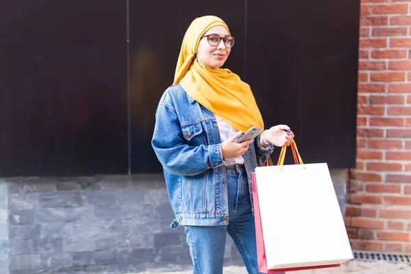 Sale and buying concept - Happy arab muslim girl with shopping bags after mall — Stock Photo, Image