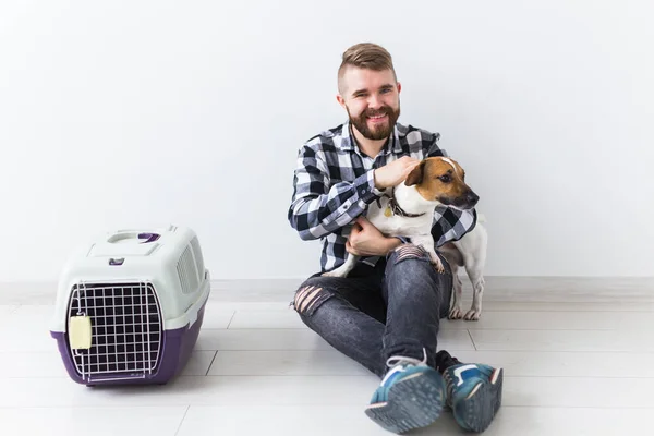 Bolsas de transporte de perros y mascotas concepto de propietario Atractivo hombre alegre en camisa a cuadros tiene mascota favorita. Feliz hombre barbudo con su gato russell terrier — Foto de Stock