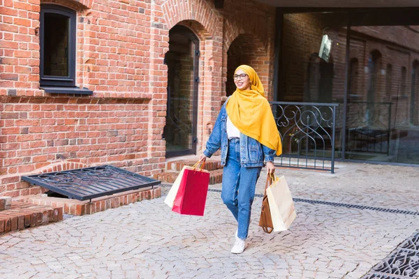 Satış ve satın alma konsepti - Alışveriş çantasıyla alışveriş yapan mutlu Arap Müslüman kız — Stok fotoğraf