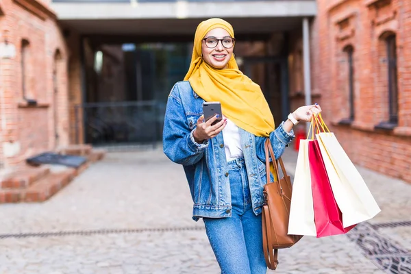 Kauf- und Verkaufskonzept - Glückliches arabisches muslimisches Mädchen mit Einkaufstüten nach Einkaufszentrum — Stockfoto