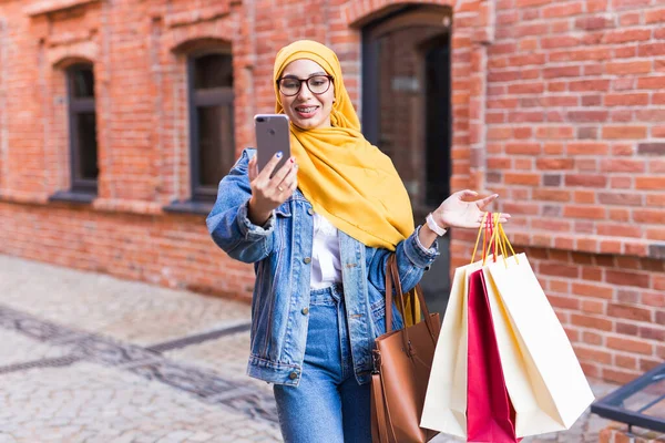 Verkauf, Technologien und Kaufkonzept - Glückliche arabische Muslimin macht nach dem Einkaufen Selfie im Freien — Stockfoto