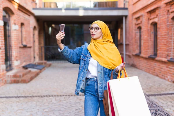 Verkauf, Technologien und Kaufkonzept - Glückliche arabische Muslimin macht nach dem Einkaufen Selfie im Freien — Stockfoto