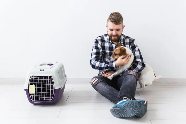 Chien portant des sacs et des animaux concept propriétaire Attrayant mâle joyeux en chemise à carreaux détient animal favori. Heureux homme barbu avec son Jack Russell Terrier — Photo