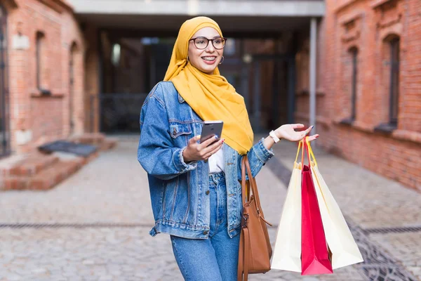 Venta y concepto de compra - Chica árabe feliz musulmán con bolsas de compras después del centro comercial —  Fotos de Stock
