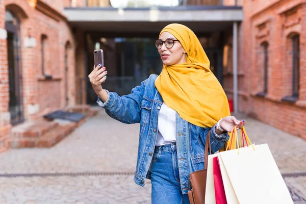Πώληση, τεχνολογίες και αγοραστική ιδέα - Happy arab muslim γυναίκα λαμβάνοντας selfie σε εξωτερικούς χώρους μετά τα ψώνια — Φωτογραφία Αρχείου